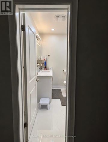 Toronto (Black Creek) apartment for rent - A bathroom with a toilet, sink and mirror.