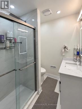 Toronto (Black Creek) apartment for rent - A bathroom with a glass shower door and a white sink.