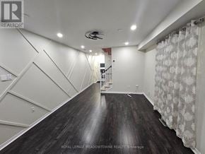 Milton (De Dempsey) apartment for rent - A spacious room with wooden floors and a staircase.