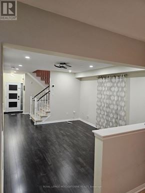 Milton (De Dempsey) apartment for rent - A spacious room with a staircase and a window with curtains.