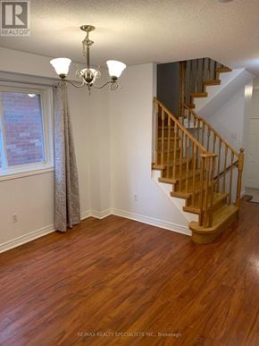 Brampton (Fletcher's Meadow) apartment for rent - A room with a wooden staircase and a chandelier.