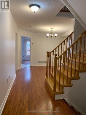Brampton (Fletcher's Meadow) apartment for rent - A hallway with a staircase and a chandelier.