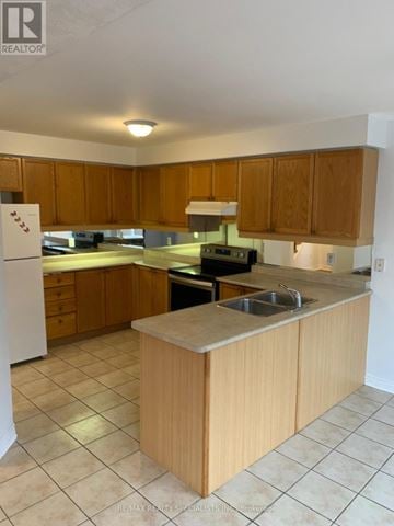 Brampton (Fletcher's Meadow) apartment for rent - A kitchen with wooden cabinets and a white refrigerator.