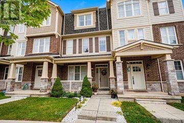 Oakville (Go Glenorchy) townhouse for rent - A large, well-maintained house with a front porch and a garage.