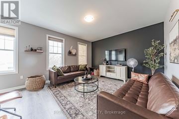 Oakville (Go Glenorchy) townhouse for rent - A living room with a brown leather couch and a glass coffee table.