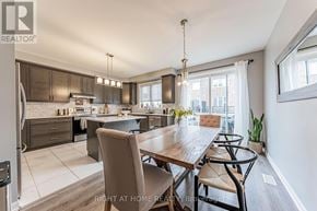 Oakville (Go Glenorchy) townhouse for rent - A modern kitchen and dining area with a wooden table and chairs.