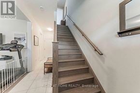 Oakville (Go Glenorchy) townhouse for rent - A staircase with a wooden handrail and a mirror above it.