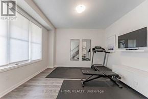 Oakville (Go Glenorchy) townhouse for rent - A room with a treadmill and a mirror on the wall.