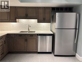 Kitchener apartment for rent - A kitchen with a refrigerator, sink, and cabinets.
