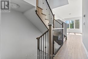 Whitby (Rolling Acres) townhouse for rent - A staircase with a wooden handrail and black balusters leads to a bright room.