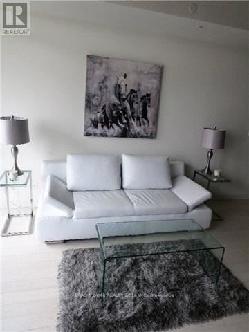 Toronto (Waterfront Communities) house for rent - A living room with a white couch and a grey rug.