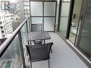 Toronto (Waterfront Communities) house for rent - A balcony with a table and chairs overlooking a cityscape.