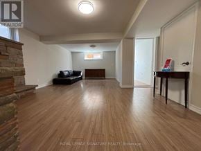 Toronto (Victoria Village) apartment for rent - A living room with wooden floors and a stone fireplace.