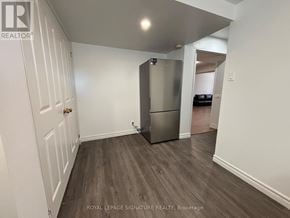Toronto (Victoria Village) apartment for rent - A white door is on the left of a room with a fridge.