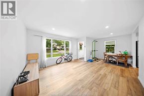 Windsor apartment for rent - A spacious room with wooden flooring and a large window overlooking a garden.