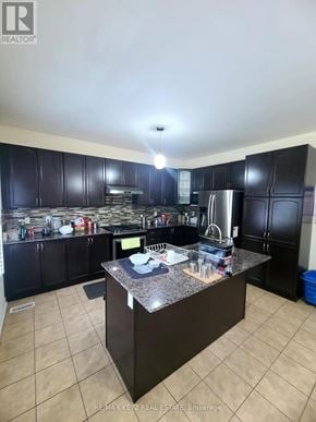 Pickering (Duffin Heights) apartment for rent - A kitchen with black cabinets and a granite countertop.