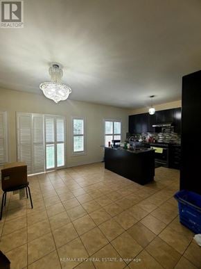 Pickering (Duffin Heights) apartment for rent - A kitchen with black cabinets and a brown chair.