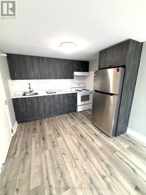 Toronto (Caledonia-Fairbank) multi-family for rent - A kitchen with a refrigerator, stove, and sink.