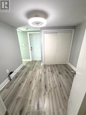 Toronto (Caledonia-Fairbank) multi-family for rent - A hallway with wood flooring and a white door.
