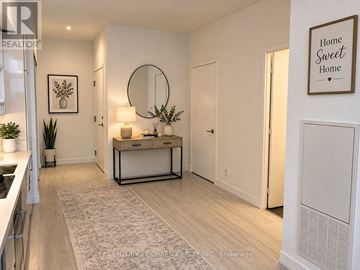 Vaughan (Vaughan Corporate Centre) condo for rent - A modern kitchen with a white cabinet and a round mirror on the wall.