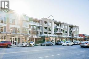 North Vancouver townhouse for rent - A sunny day at a busy street with cars and a building with a REALTOR sign.