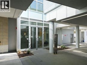 North Vancouver townhouse for rent - A building entrance with a glass door and a sign that says REALTOR.