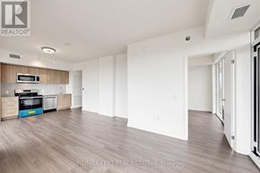 Toronto (Humber Heights) condo for rent - A spacious, empty room with a kitchenette and a microwave.