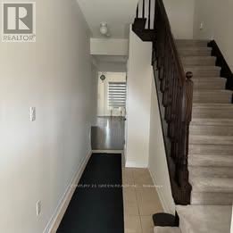 Brampton (Credit Valley) apartment for rent - A hallway with a staircase and a black carpet.