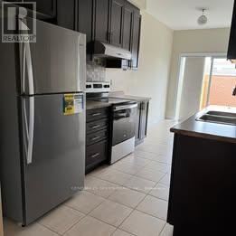 Brampton (Credit Valley) apartment for rent - A kitchen with a refrigerator, oven, and microwave.