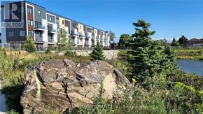 Toronto (Downsview-Roding-Cfb) townhouse for rent - A large rock in the foreground with a building in the background.