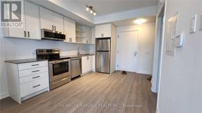 Toronto (Downsview-Roding-Cfb) townhouse for rent - A kitchen with white cabinets and a wooden floor.