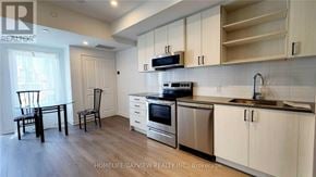 Toronto (Downsview-Roding-Cfb) townhouse for rent - A kitchen with wooden floors and white walls.