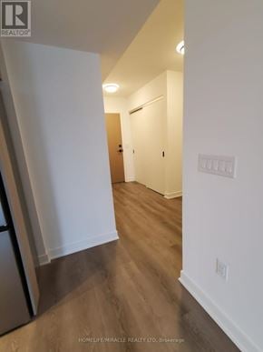 Toronto (Islington-City Centre West) condo for rent - A hallway with wood flooring and white walls.