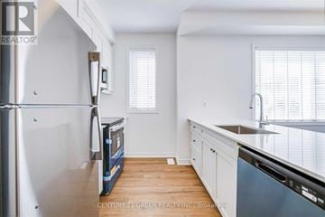 Hamilton (Parkview) townhouse for rent - A kitchen with white cabinets and a stainless steel refrigerator.