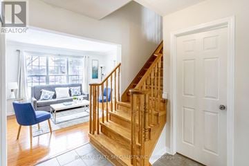 Milton (Cl Clarke) apartment for rent - A living room with a blue chair and a wooden staircase.