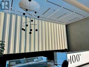 Toronto (Waterfront Communities) condo for rent - A modern living room with a sofa and a ceiling light.