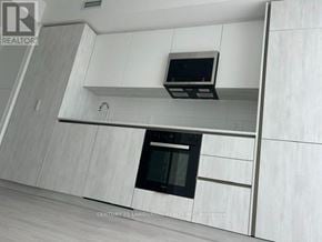 Toronto (Waterfront Communities) condo for rent - A modern kitchen with a microwave oven built into the cabinetry.