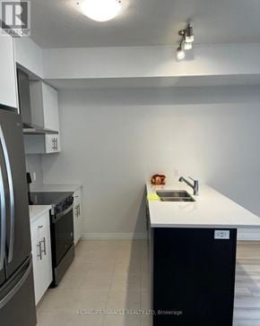 Guelph (Kortright East) townhouse for rent - A kitchen with a sink, stove, and refrigerator.