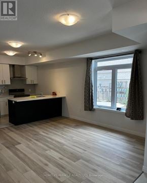 Guelph (Kortright East) townhouse for rent - A kitchen with a black countertop and wooden flooring.