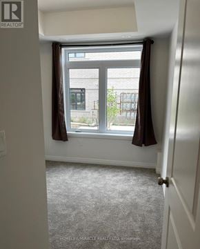 Guelph (Kortright East) townhouse for rent - A room with a window and curtains, with a sign that says "REALTOR".