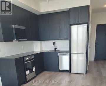 Milton (Om Old Milton) condo for rent - A kitchen with black cabinets and a white refrigerator.