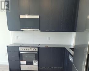 Milton (Om Old Milton) condo for rent - A kitchen with black cabinets and a stove top oven.