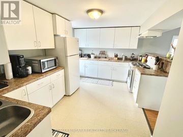 Welland (Lincoln/Crowland) duplex for rent - A kitchen with white cabinets and appliances.