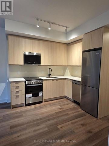 Milton (Tm Timberlea) condo for rent - A kitchen with wooden cabinets and stainless steel appliances.