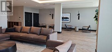 Milton (Tm Timberlea) condo for rent - A living room with a brown couch and a wooden table.