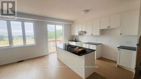 Woodstock (Woodstock - South) townhouse for rent - A kitchen with white cabinets and a large island in the middle.