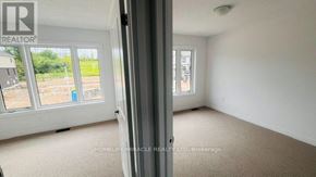 Woodstock (Woodstock - South) townhouse for rent - A room with a carpeted floor and a view of a construction site through the window.