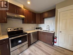 West Vancouver apartment for rent - A kitchen with brown cabinets and a stainless steel oven.