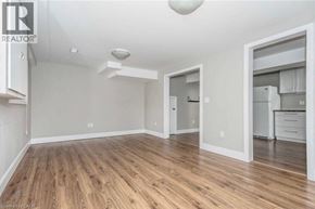 Cambridge apartment for rent - A spacious room with wooden flooring and a kitchen area visible through the doorway.