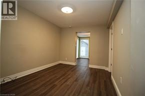 Hamilton apartment for rent - A room with wooden floors and a doorway leading to another room.
